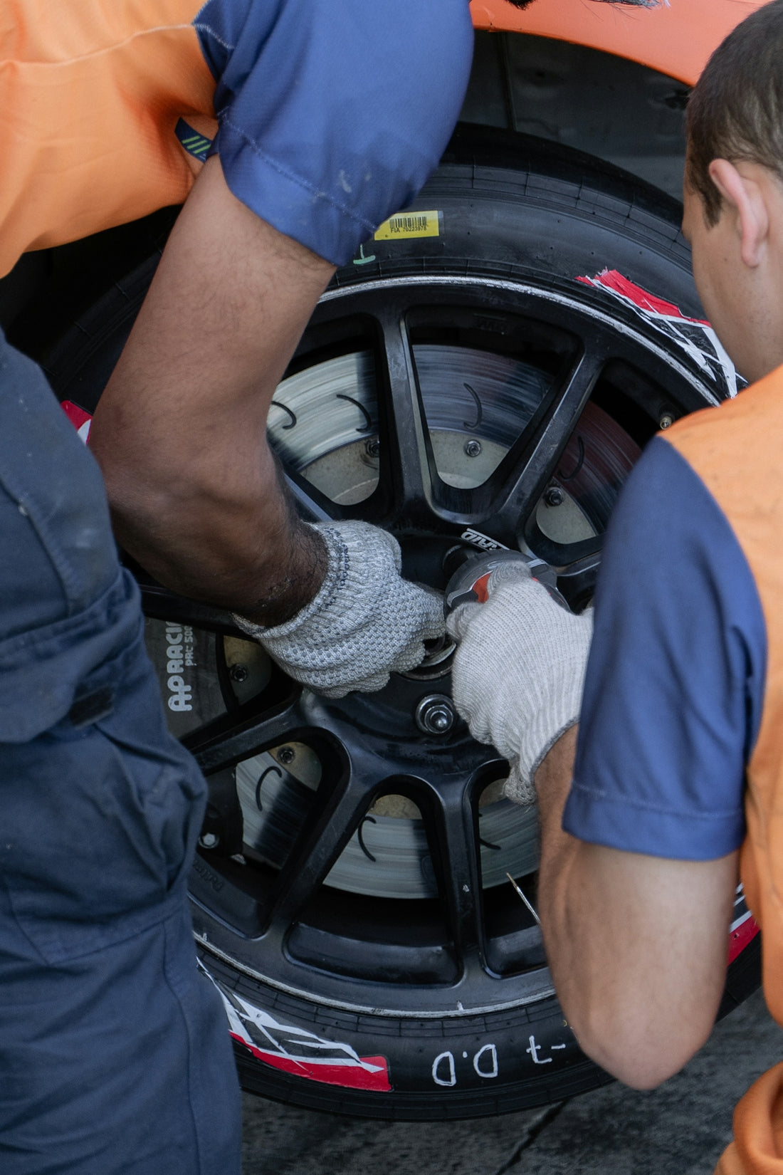 two men working on a tire on a car