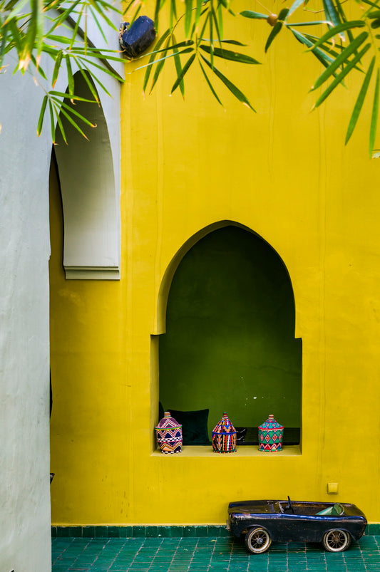 a toy car sitting in front of a yellow wall